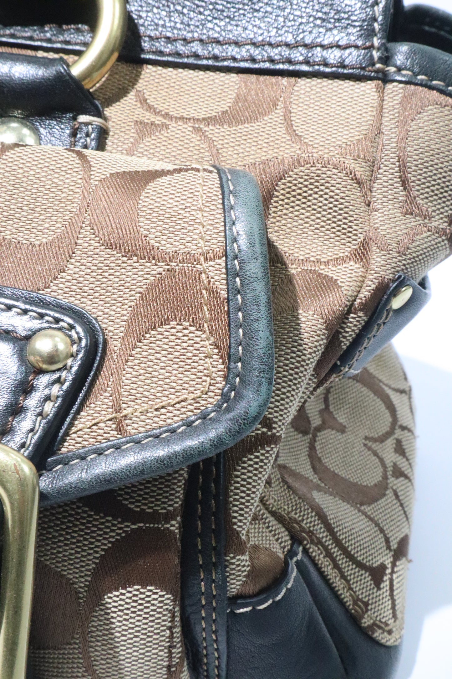 Close-up of Coach Brown Signature 65th Anniversary Legacy Turnlock Rare Edition handbag showing canvas and leather details.