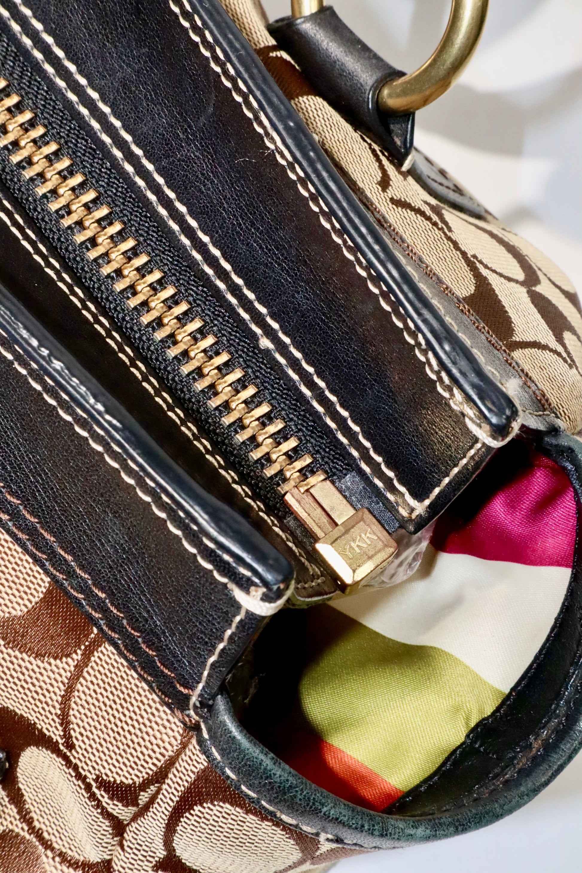 Close-up view of the Coach Brown Signature 65th Anniversary Legacy Turnlock Rare Edition bag showing the zipper and lining details.