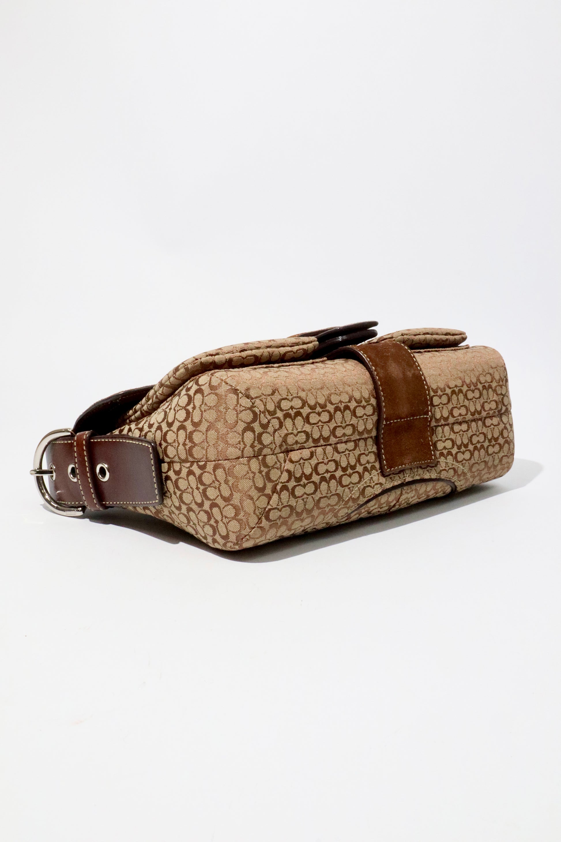 Coach 2005 Vintage Soho Buckle Shoulder Bag in Brown Suede displayed from the side, showcasing its unique design.