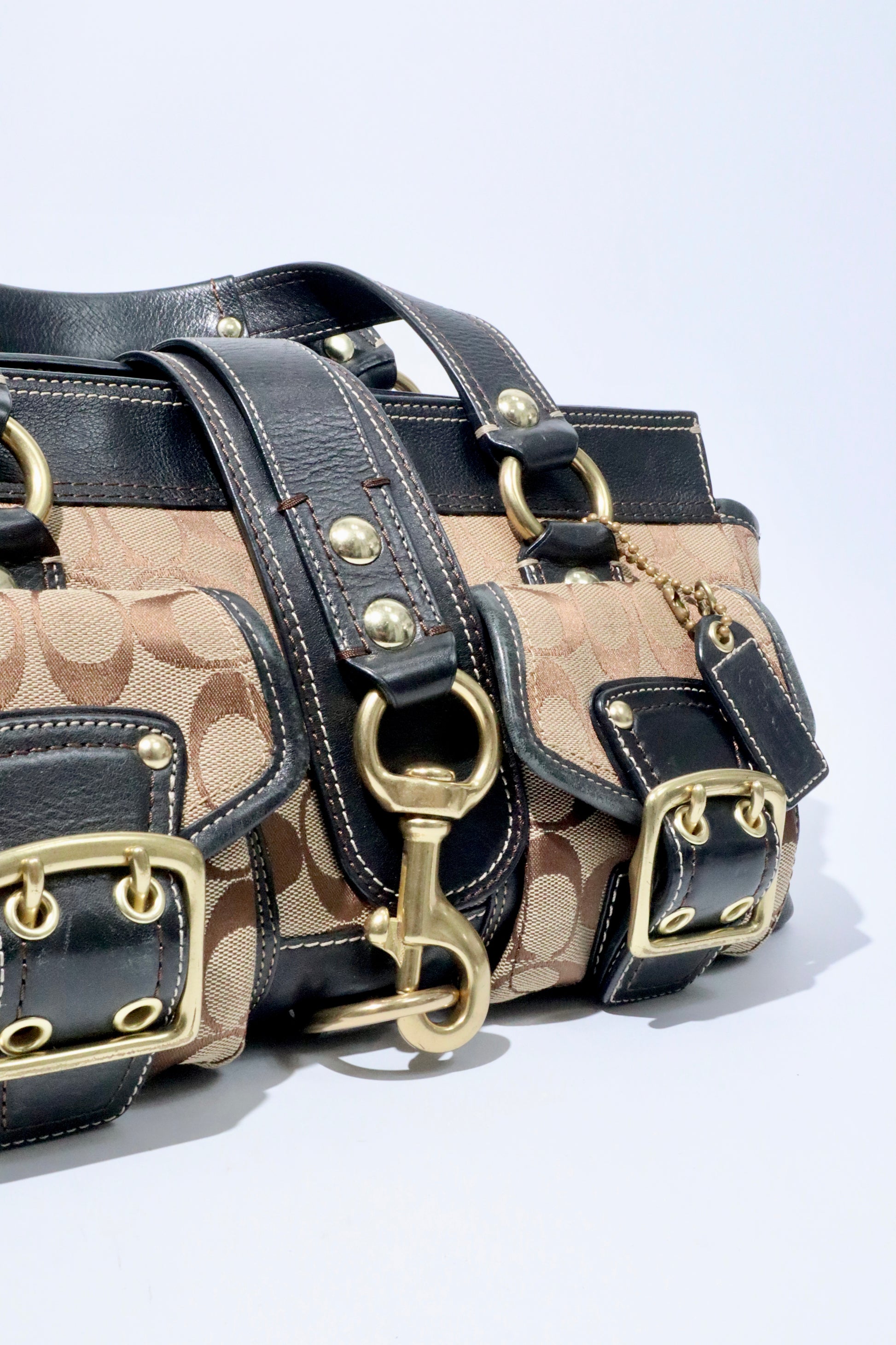 Close-up of Coach Brown Signature 65th Anniversary Legacy Turnlock Rare Edition bag showcasing its canvas and leather design.