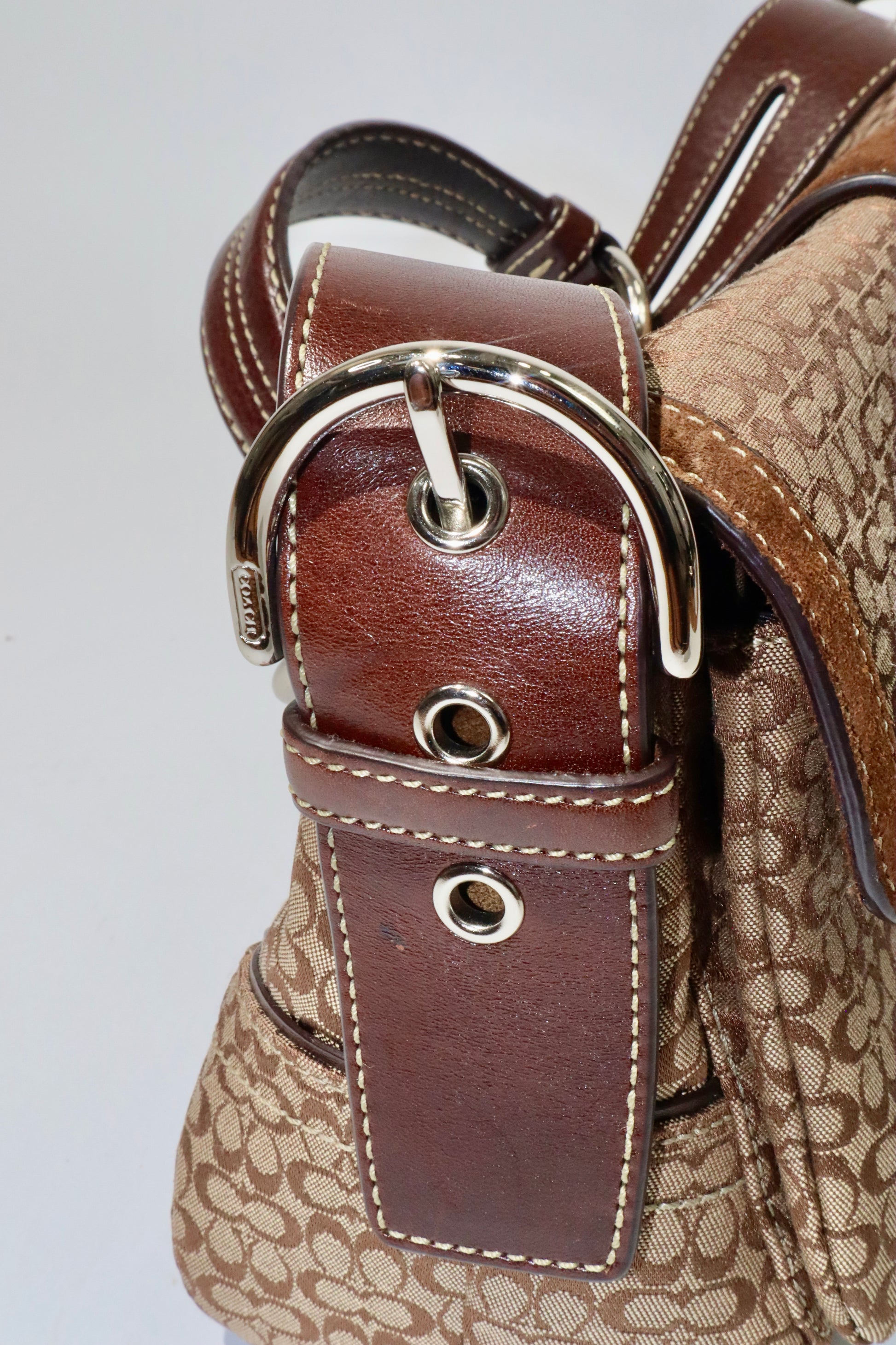 Detail view of the Coach 2005 Vintage Soho Buckle Shoulder Bag in Brown Suede showcasing the shoulder strap and buckle.