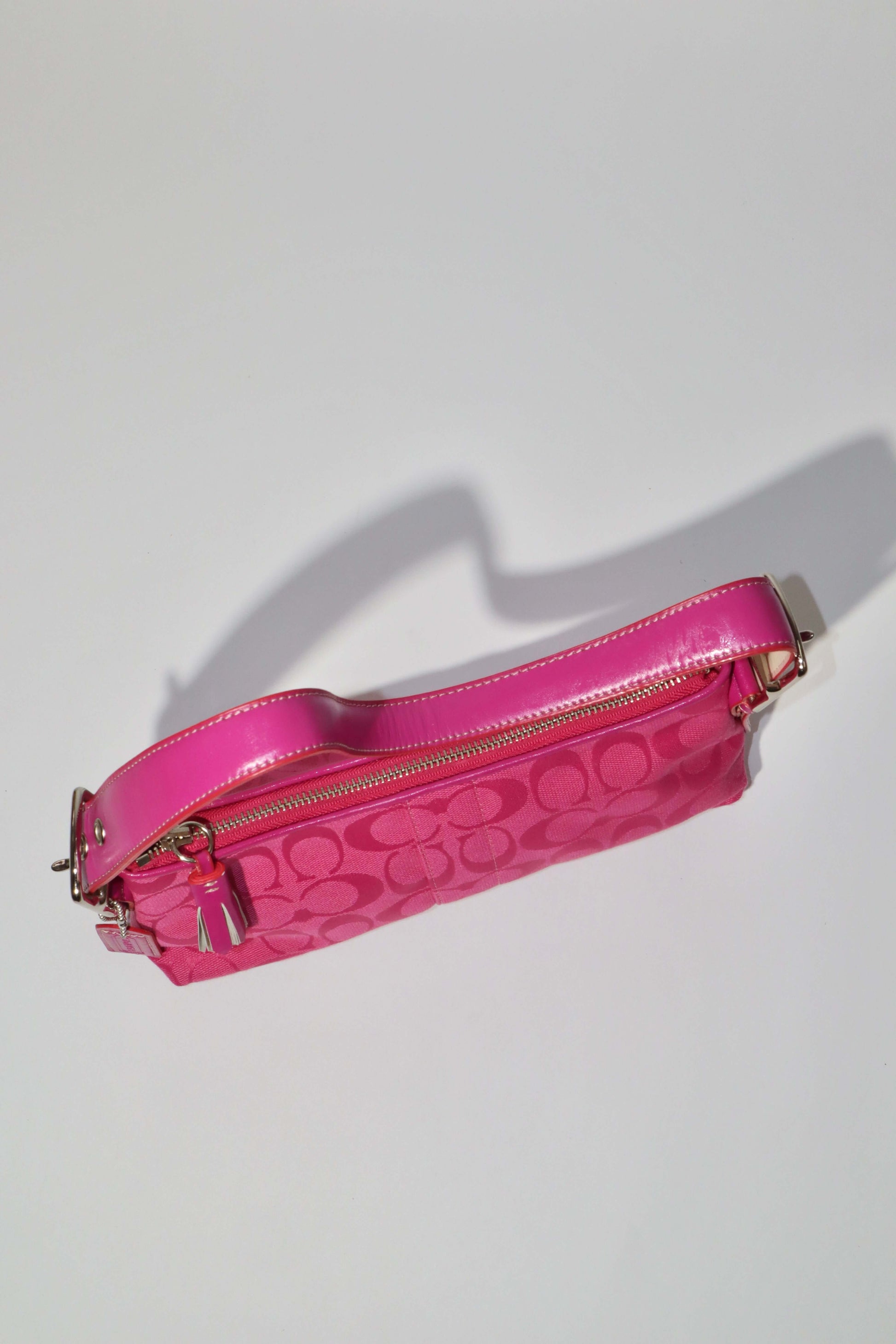 Vintage Coach Hot Pink Baguette Demi Shoulder Bag displayed from above with signature monogram canvas and bright leather trim.